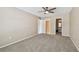 Spacious bedroom featuring neutral walls, ceiling fan, carpet, and an en-suite bathroom at 3389 Crystal E Ct # J, Palm Harbor, FL 34685
