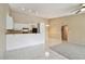 Open-concept kitchen and living area with bar seating, white cabinets and black appliances at 3389 Crystal E Ct # J, Palm Harbor, FL 34685