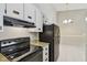 Galley kitchen showcasing white cabinetry and sleek black appliances at 3389 Crystal E Ct # J, Palm Harbor, FL 34685