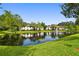 Community pond with fountain, lush lawns and condos in the background at 3389 Crystal E Ct # J, Palm Harbor, FL 34685