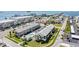 Aerial view of beach condos with a pool and meticulously landscaped grounds near the ocean at 340 Causeway Blvd # 105, Dunedin, FL 34698