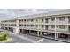 This exterior view displays the condo's three-story building with parking underneath, providing convenient access at 340 Causeway Blvd # 105, Dunedin, FL 34698