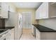 Galley kitchen features sleek countertops, white appliances, and ample cabinet space, great for meal prep at 340 Causeway Blvd # 105, Dunedin, FL 34698