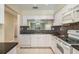 Bright and modern kitchen boasts white cabinets, mosaic backsplash, and a view into the living area at 340 Causeway Blvd # 105, Dunedin, FL 34698