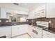 Bright kitchen features white cabinets, mosaic backsplash, and modern appliances, perfect for cooking enthusiasts at 340 Causeway Blvd # 105, Dunedin, FL 34698