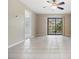 Spacious living room featuring tile floors and sliding glass doors leading to outdoor at 340 Causeway Blvd # 105, Dunedin, FL 34698