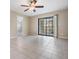 Spacious living room with tiled floor, fan and sliding door to the patio at 340 Causeway Blvd # 105, Dunedin, FL 34698