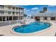 Inviting community pool with a shallow end, lounge chairs and a secure fence at 340 Causeway Blvd # 105, Dunedin, FL 34698