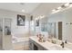 Well-lit bathroom with double sink vanity, separate shower, and soaking tub at 34447 Windknob Ct, Wesley Chapel, FL 33545