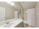 Bathroom featuring shower-tub combo, single sink vanity with ample lighting at 34447 Windknob Ct, Wesley Chapel, FL 33545