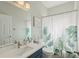 Bright bathroom features a modern vanity, toilet and shower with stylish curtain at 34447 Windknob Ct, Wesley Chapel, FL 33545