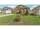 Inviting home exterior featuring a lush lawn and beautiful tropical landscaping at 34447 Windknob Ct, Wesley Chapel, FL 33545