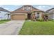 Charming home exterior with well-maintained landscaping and an attached two-car garage at 34447 Windknob Ct, Wesley Chapel, FL 33545