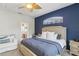 Comfortable main bedroom features a blue accent wall, chair, and en-suite bathroom at 34447 Windknob Ct, Wesley Chapel, FL 33545