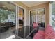 Enclosed patio with outdoor furniture overlooking the backyard and access to kitchen at 34447 Windknob Ct, Wesley Chapel, FL 33545