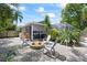 Backyard showcasing a stone fire pit, chairs, beautiful greenery and gravel at 4047 Eagle Cove West Dr, Palm Harbor, FL 34685