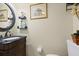 Powder room featuring a dark wood vanity, a round mirror, decorative shelves, and neutral wall color at 4047 Eagle Cove West Dr, Palm Harbor, FL 34685
