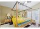 Primary bedroom with a four-poster bed, dark wood floors, and backyard access at 4047 Eagle Cove West Dr, Palm Harbor, FL 34685