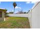 The backyard features a privacy fence, a well-manicured lawn, and mature landscaping at 431 Windward Psge, Clearwater Beach, FL 33767