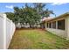 Wide backyard featuring grass, a large shade tree, and a white fence at 431 Windward Psge, Clearwater Beach, FL 33767