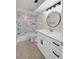 Well-lit bathroom featuring a modern vanity, round mirror, and bathtub with decorative tiled wall at 431 Windward Psge, Clearwater Beach, FL 33767