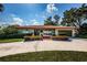 Charming home with a red tile roof, lush landscaping, and a well-maintained front yard at 431 Windward Psge, Clearwater Beach, FL 33767