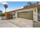 View of the garage with blooming bushes, showcasing the driveway and exterior at 431 Windward Psge, Clearwater Beach, FL 33767