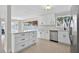 Open kitchen featuring white cabinets, stainless steel appliances, and access to a patio at 431 Windward Psge, Clearwater Beach, FL 33767