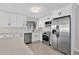 Bright kitchen featuring stainless steel appliances, modern white cabinetry and speckled countertops at 431 Windward Psge, Clearwater Beach, FL 33767