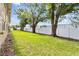 A spacious backyard featuring a well-manicured lawn, mature trees, and a white vinyl fence at 4500 E Bay Dr # 106, Clearwater, FL 33764