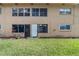 View of backyard with lawn and house, with patio door entrance at 4500 E Bay Dr # 106, Clearwater, FL 33764