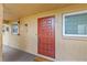 Condo entryway with a red door, textured walls, and nearby windows providing natural light at 4500 E Bay Dr # 106, Clearwater, FL 33764
