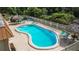 Aerial view of community swimming pool with lounge chairs and tiki umbrellas at 4500 E Bay Dr # 106, Clearwater, FL 33764