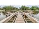 A charming wooden dock extends into the serene lake, offering a peaceful spot for fishing and relaxation at 4513 S Oak Dr # Q21, Tampa, FL 33611
