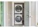 A view of the white stacked washer and dryer unit with a gray front, conveniently located near the entryway at 4513 S Oak Dr # Q21, Tampa, FL 33611