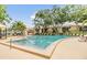 The community pool is surrounded by mature trees, lounge chairs and umbrellas, creating a relaxing environment at 4513 S Oak Dr # Q21, Tampa, FL 33611