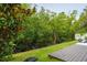 Serene backyard featuring green grass, lush foliage, and a charming wooden patio at 4806 W Euclid Ave, Tampa, FL 33629
