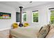 Bright bedroom featuring modern decor, a sleek fireplace, and a view of lush greenery at 4806 W Euclid Ave, Tampa, FL 33629