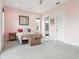 Charming bedroom featuring pink walls, a plush bed, and a woven storage chest at 4806 W Euclid Ave, Tampa, FL 33629