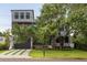Striking modern home with metal accents, dark trim, a well-manicured lawn and mature tree at 4806 W Euclid Ave, Tampa, FL 33629