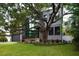Contemporary home featuring stone accents, expansive glass windows, and a lush, landscaped front yard at 4806 W Euclid Ave, Tampa, FL 33629