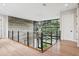 Upstairs hallway featuring a decorative chandelier and access to natural light from large windows at 4806 W Euclid Ave, Tampa, FL 33629