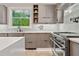Modern kitchen featuring stainless steel appliances, light wood cabinetry, and bright subway tile backsplash at 4806 W Euclid Ave, Tampa, FL 33629
