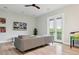 Living room featuring a modern ceiling fan, French doors with balcony, and a large sectional sofa at 4806 W Euclid Ave, Tampa, FL 33629