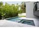 Beautiful in-ground pool and spa with modern tile and stone surround, and lush landscaping at 4806 W Euclid Ave, Tampa, FL 33629