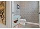 Stylish powder room with a unique wallpaper, modern vanity, and mosaic tile flooring at 4806 W Euclid Ave, Tampa, FL 33629