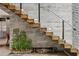 Unique floating staircase with wood treads and a built-in water feature, creating a striking architectural design at 4806 W Euclid Ave, Tampa, FL 33629