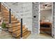 Modern staircase with wood treads, cable railing, and concrete wall, leading to the bedroom at 4806 W Euclid Ave, Tampa, FL 33629