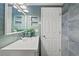 Remodeled bathroom with white vanity, tiled walls, accent mirror, and decorative lighting at 4931 Pelican Dr, New Port Richey, FL 34652