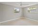 This cozy bedroom features neutral paint, carpet, and two windows at 4931 Pelican Dr, New Port Richey, FL 34652